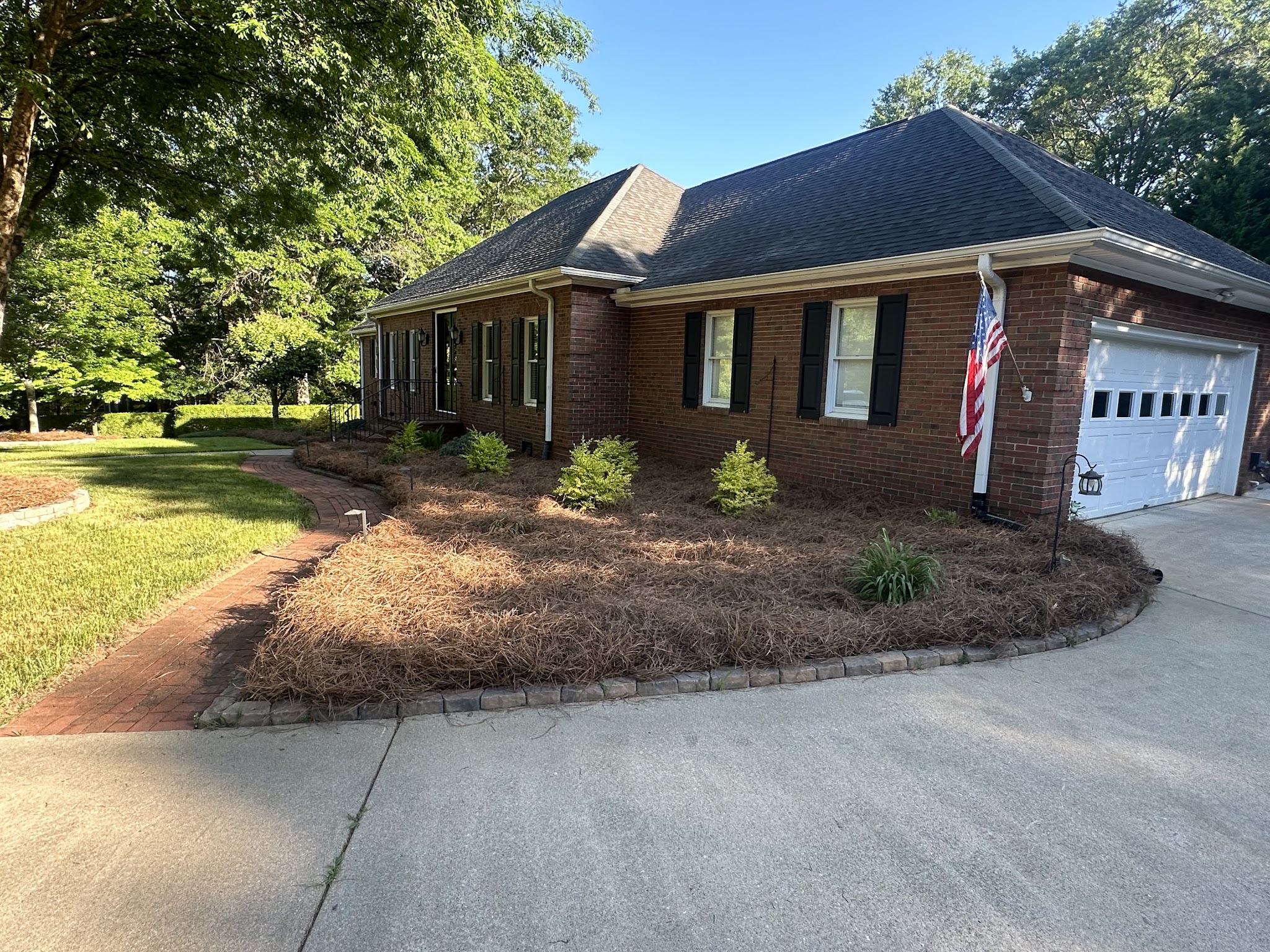 Edged pine straw bed beside a driveway