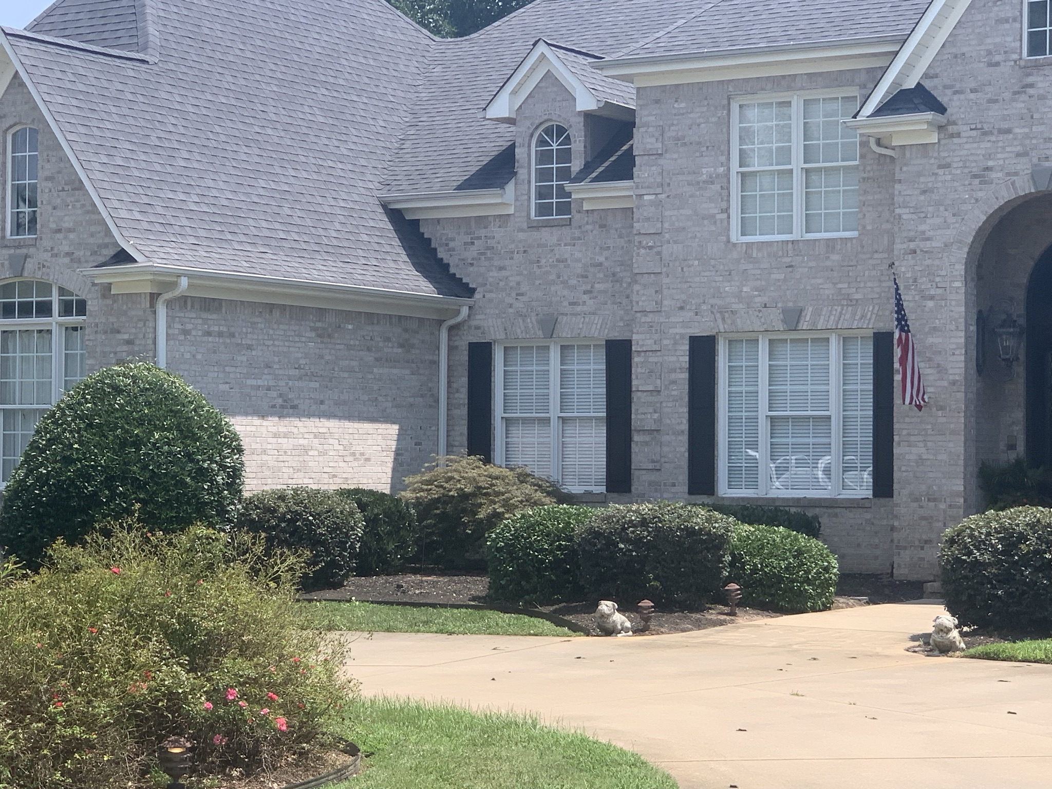 Neat shrubs in front of a brick house